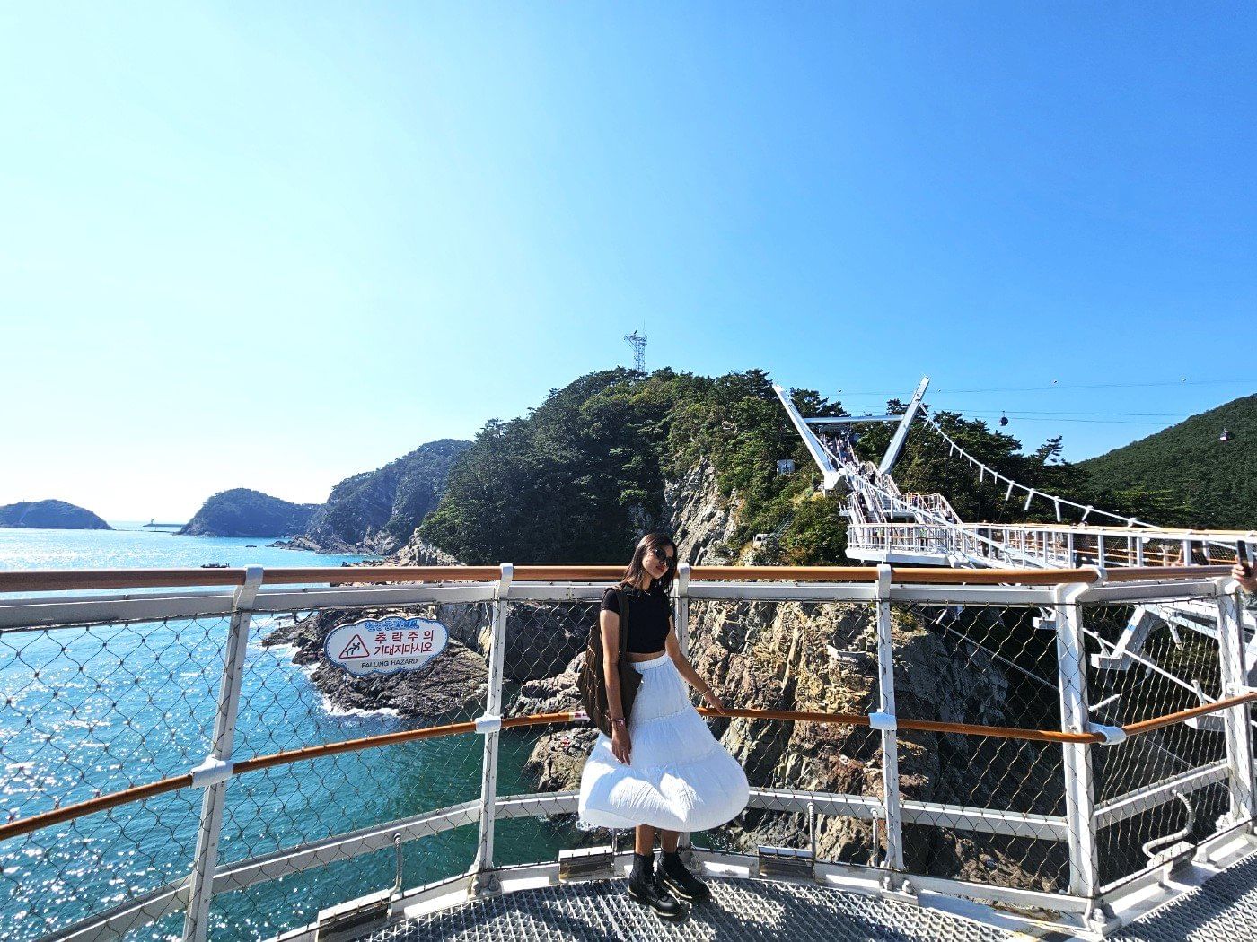 Visitors walking along the Songdo Yonggung Cloud Bridge with ocean cliffs below.