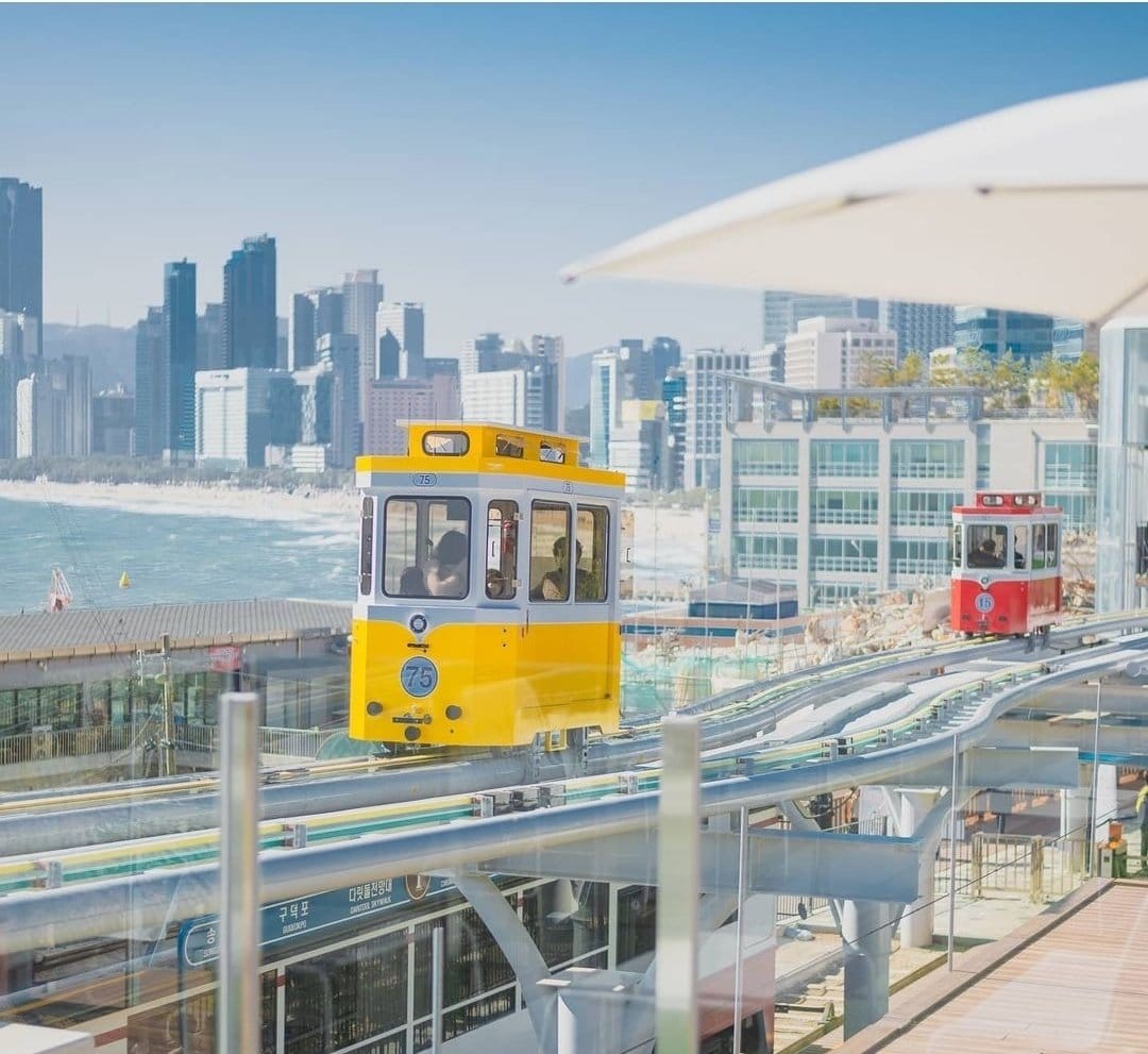 The colorful Blueline Capsule Train riding along the Haeundae coastline.