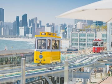 The colorful Blueline Capsule Train riding along the Haeundae coastline.