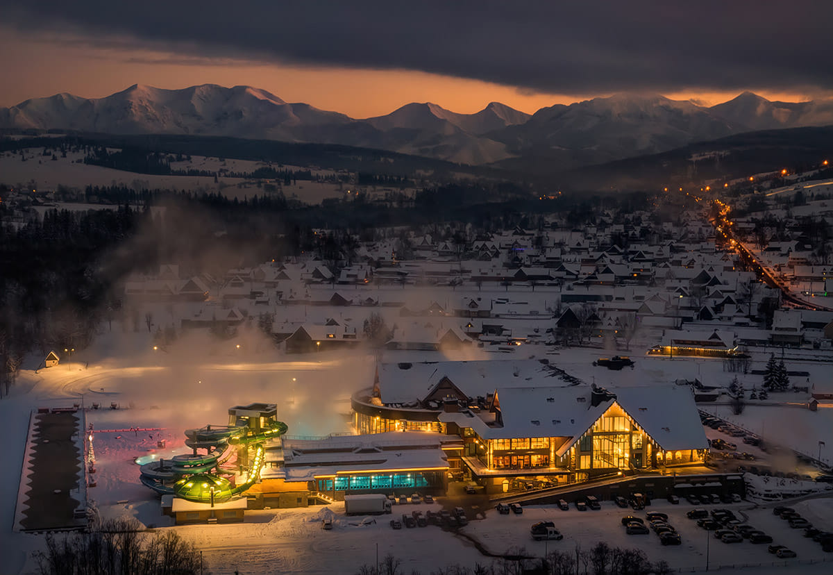 Chochołów Thermal Baths outdoor pools at dusk — water slides blue pools evening atmosphere Podhale