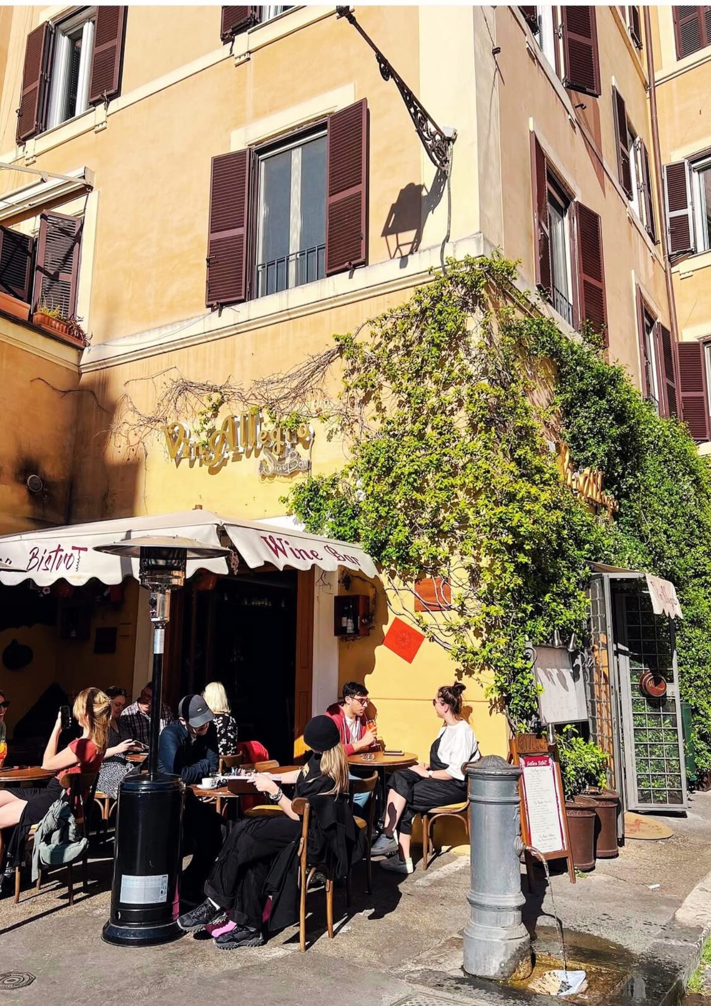 Outdoor tables in Trastevere, Rome, under vines and warm walls—an easy pause before the next bite.