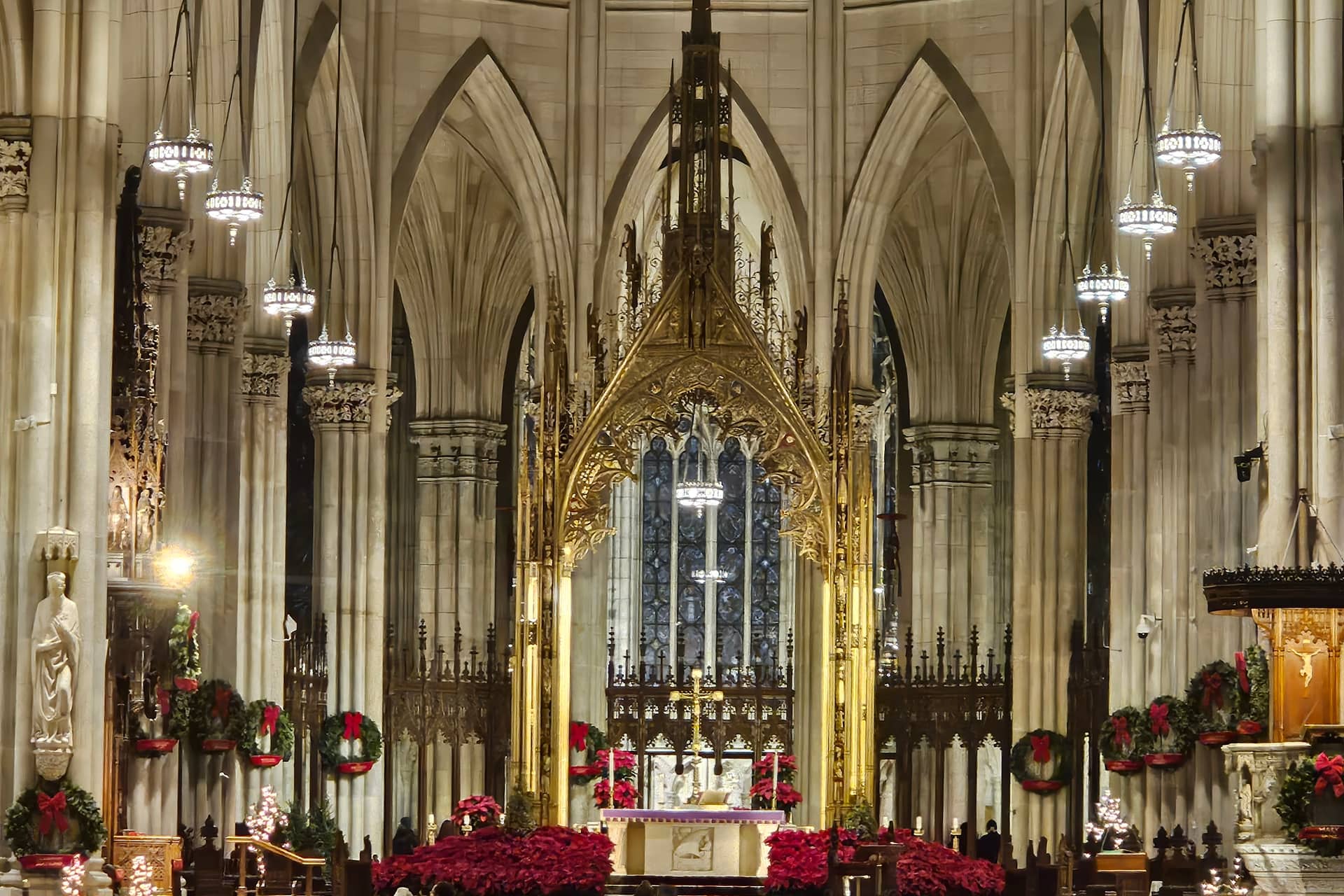 St. Patrick's Cathedral altar decorated with red poinsettias and holiday wreaths during Christmas season