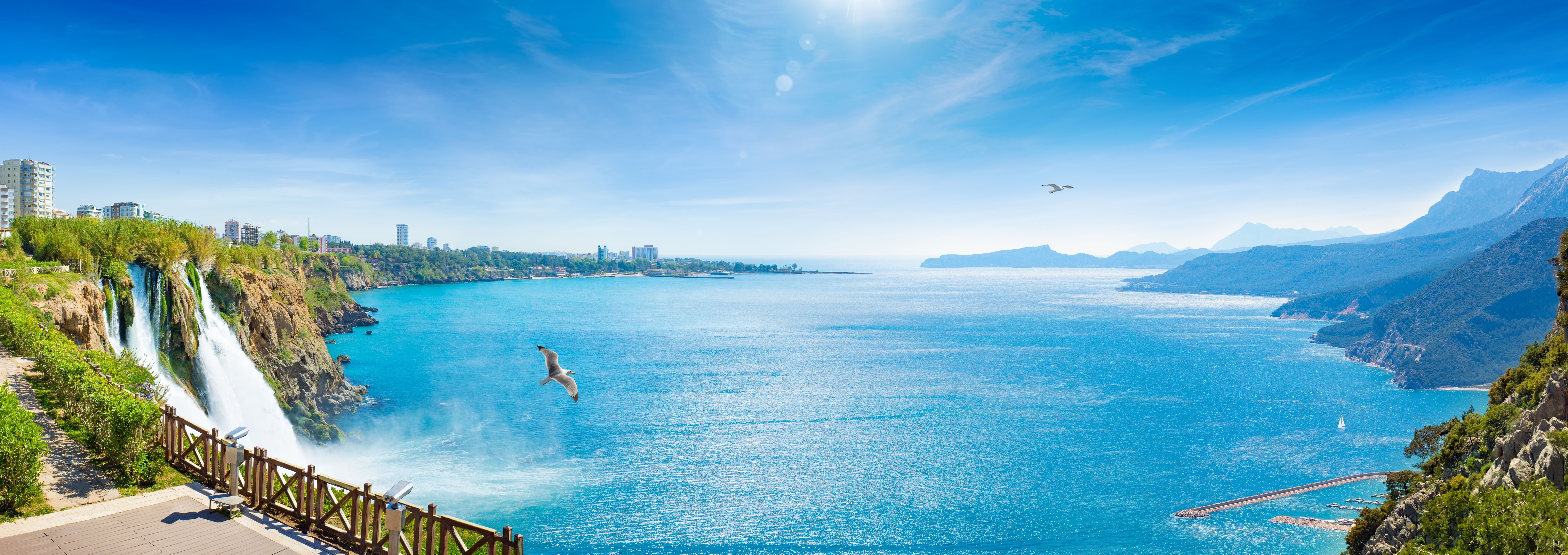 “Panoramic view of Antalya’s coastline and city skyline as seen from the sea on a clear, sunny day.”