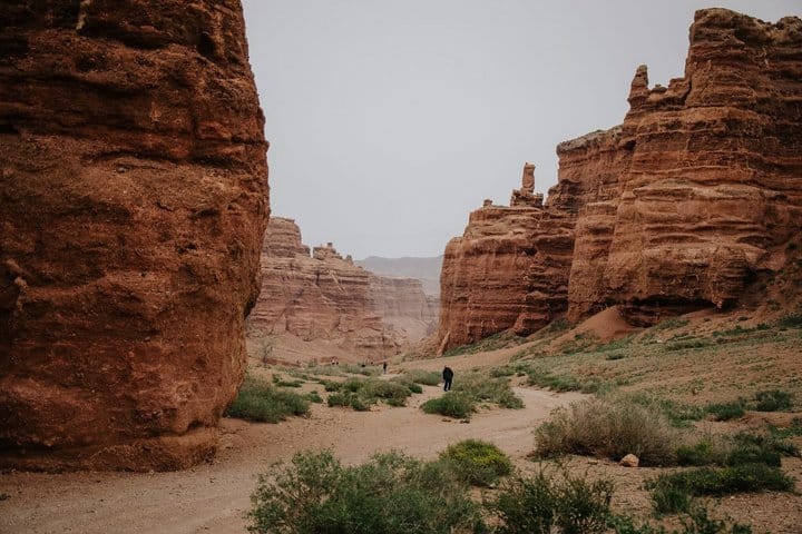 Red rock canyon with towering cliffs and dramatic desert landscape in Kazakhstan.