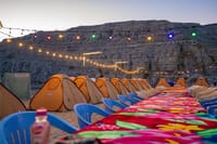 Your picturesque dining setup awaits! Enjoy a freshly prepared BBQ Dinner and a cozy Overnight stay under the illuminated cliffs on your Musandam Khasab Dhow Cruise.