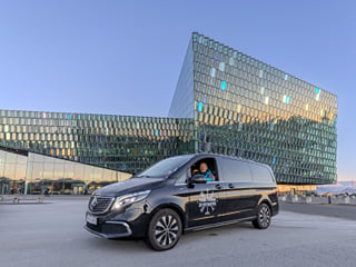 A tour vehicle from Your Friend in Reykjavik in front of the Harpa Concert Hall