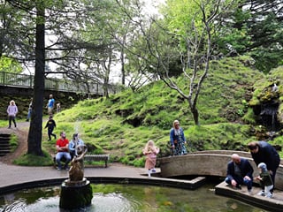 Scenic view of Hellisgerði urban park with lava rock formations and greenery