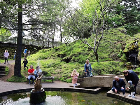 Scenic view of Hellisgerði urban park with lava rock formations and greenery