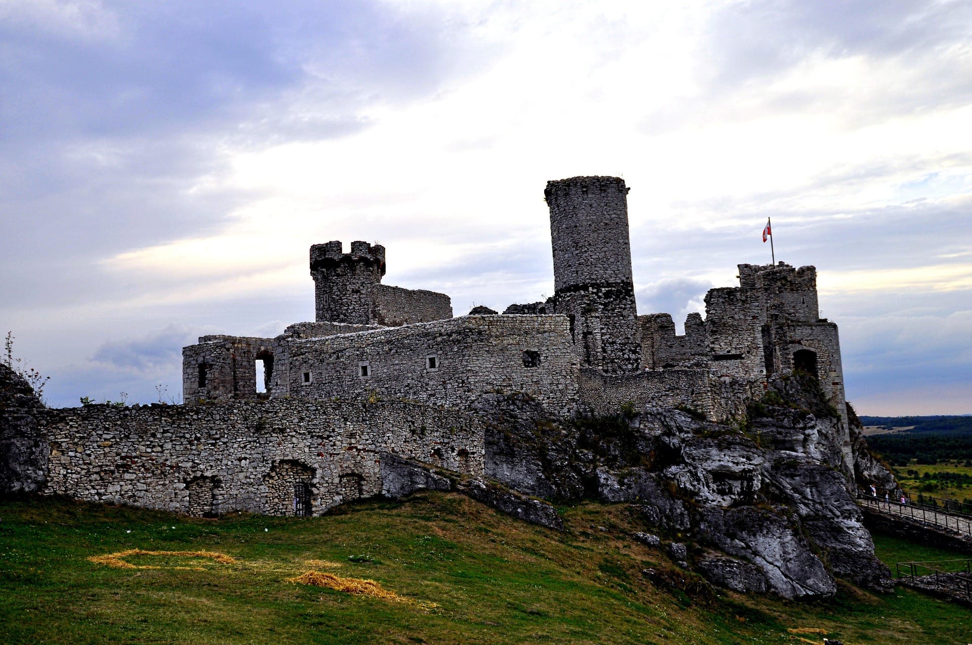 Ogrodzieniec Castle at dusk — ruins silhouetted against dramatic sky