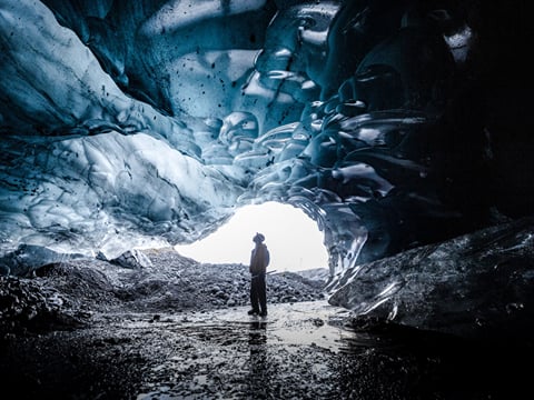 People exploring ice cave during glacier hike and ice cave tour Iceland