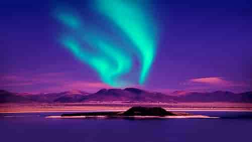 Northern Lights over Mountain overlooking lake in Iceland