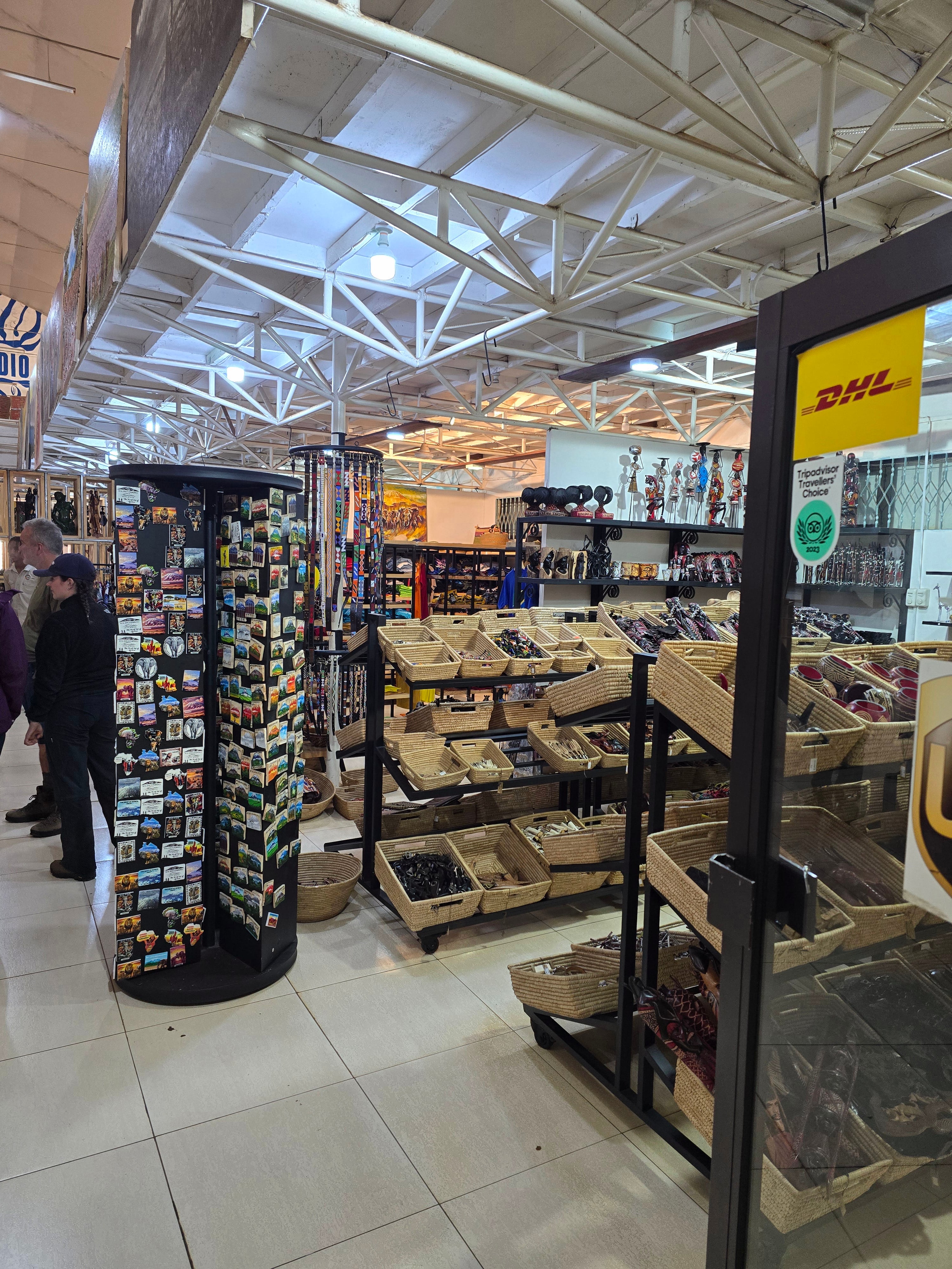 A souvenir shop interior featuring rotating postcard display racks and shelves filled with local crafts.
