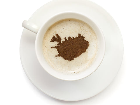A cup of coffee with the shape of Iceland as cacao-art