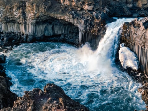 Large waterfall cascading into a rocky riverbed