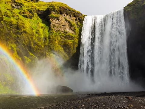 Skógarfoss waterfall decorated with magical rainbow