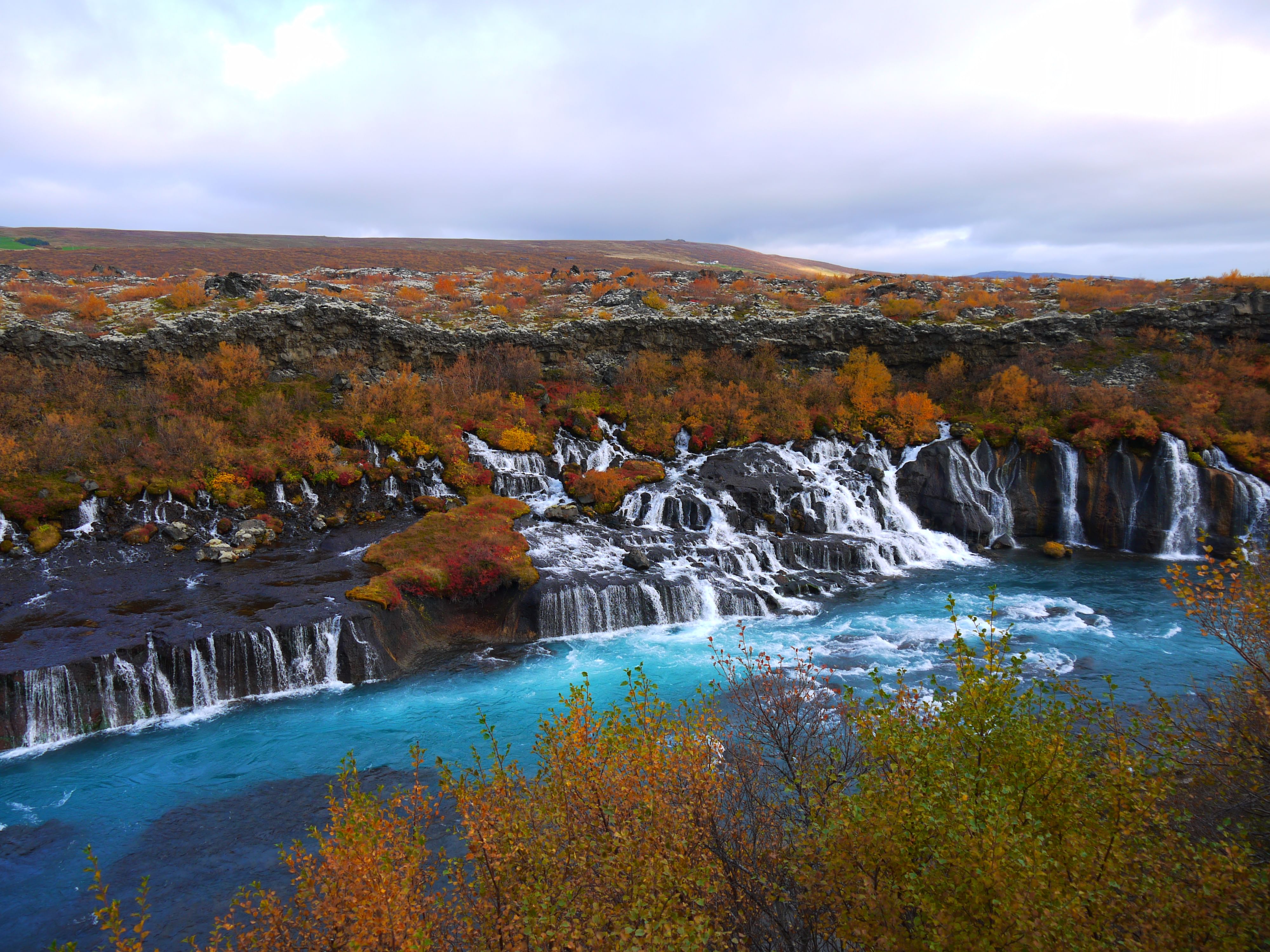 Overview of colourful Hraunfossar Waterfalls during arctic adventures Iceland