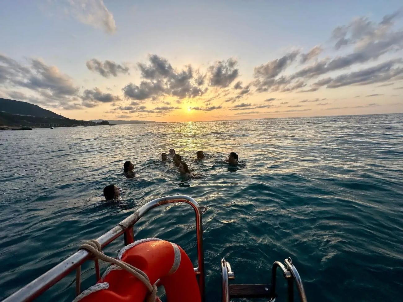 Persone che nuotano in acque cristalline lungo la Costa Viola