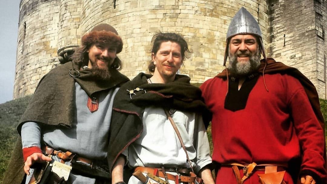 Three viking men stood in front of Clifford's Tower, York.