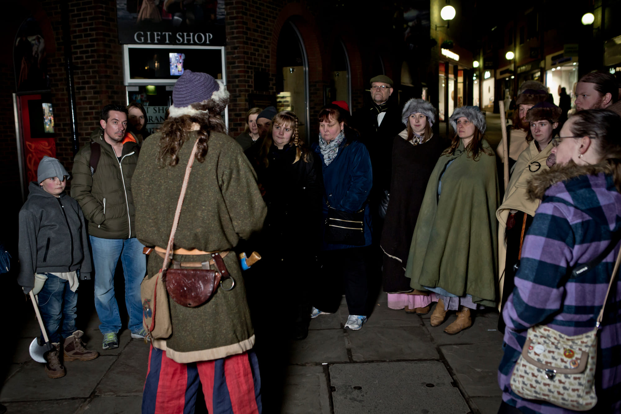 A viking stood with his large group of guests outside the Jorvik Viking Centre, Coppergate, York.