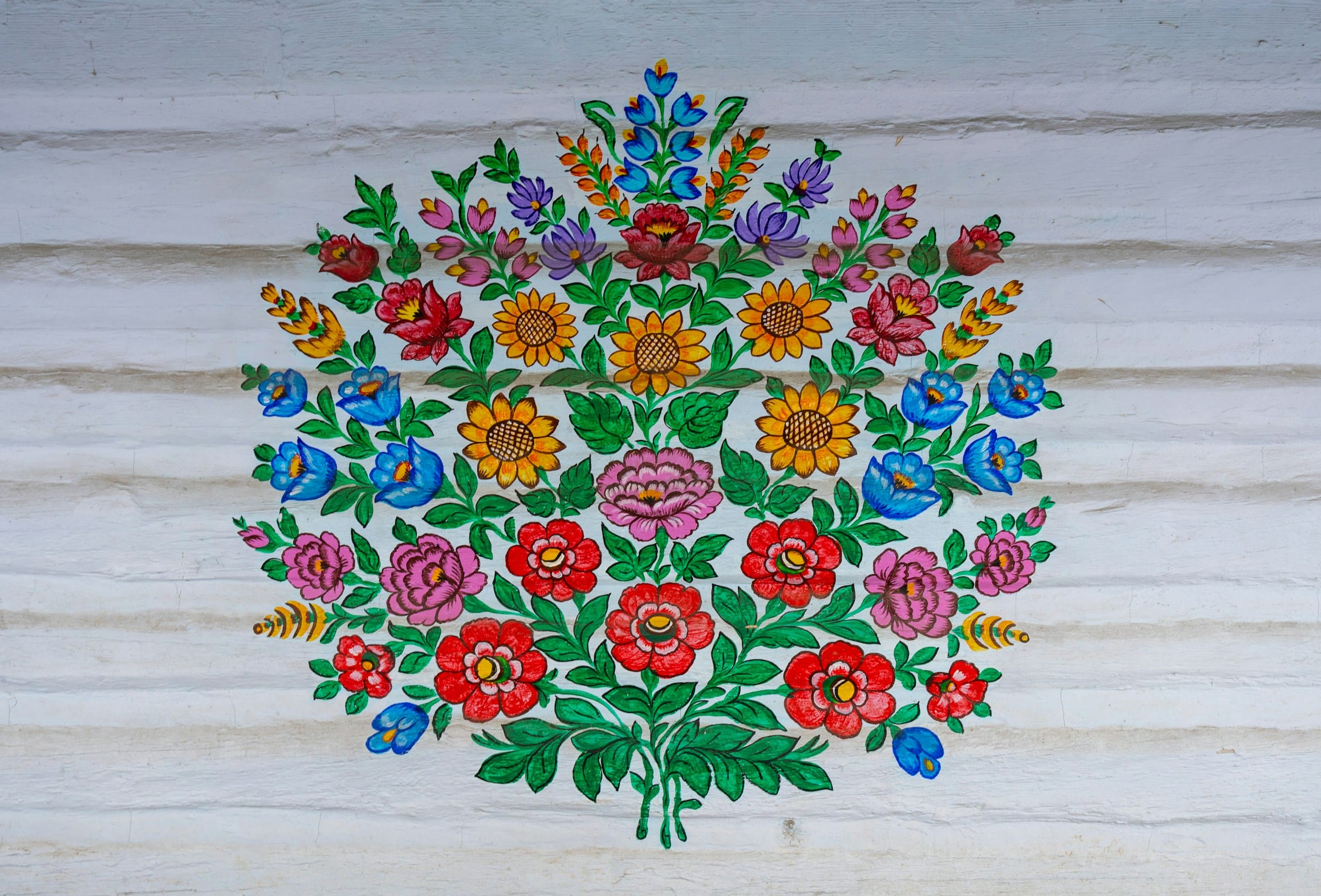 Zalipie folk art floral motif close-up — hand-painted flower bouquet on white cottage wall Poland