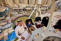 A family dining in the air at Flying Cup Dubai with smiles on their faces.