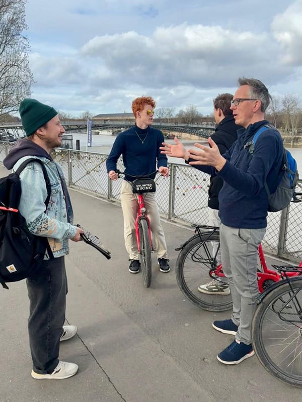 The guide telling a story to the group on a bridge over the Seine