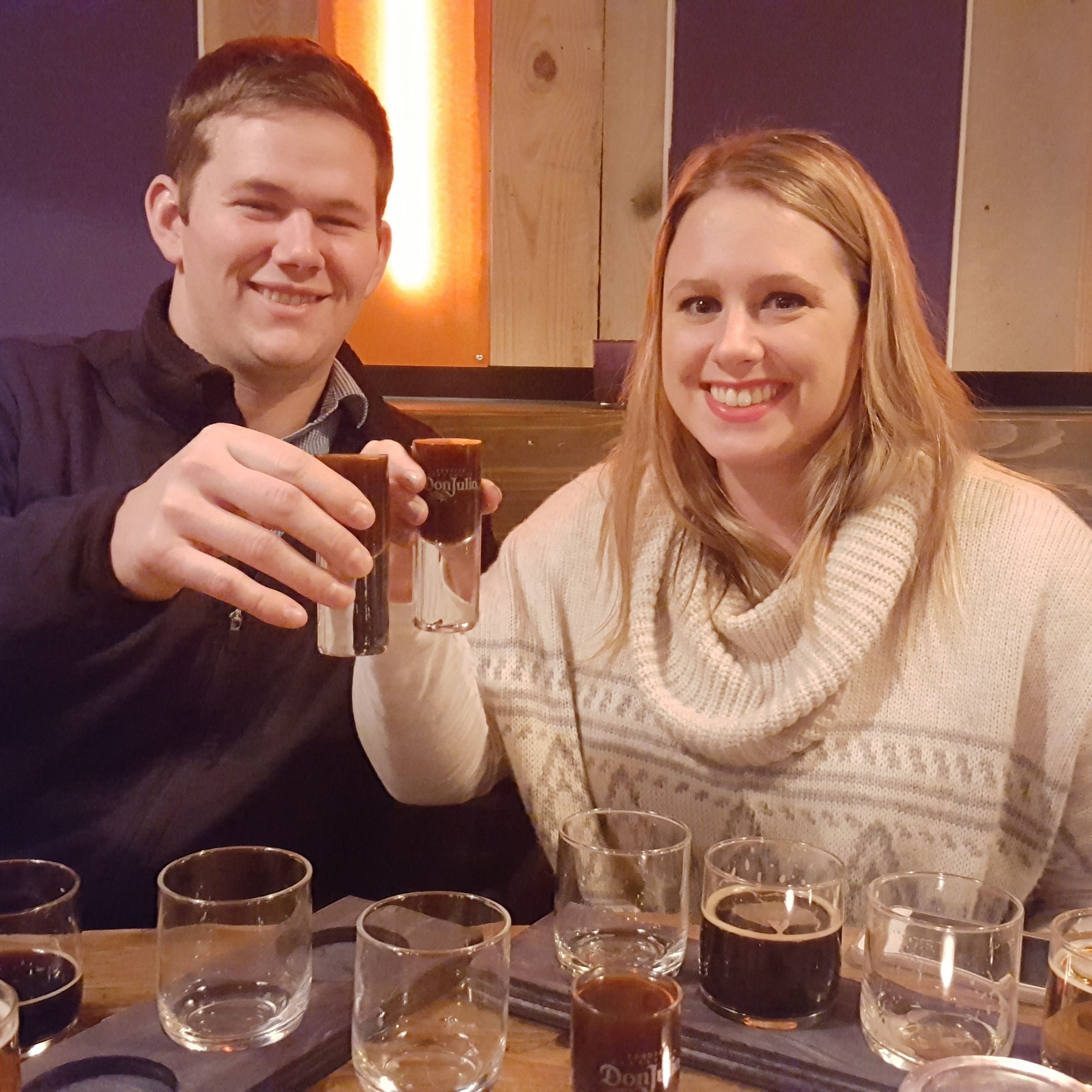 A couple enjoying a glass of snaps after sampling beers