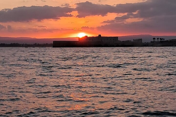 Sunset over the sea with orange sky near Ortigia, Sicily