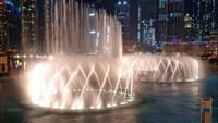 Boat gliding through the shimmering waters of the Dubai Fountains lake.