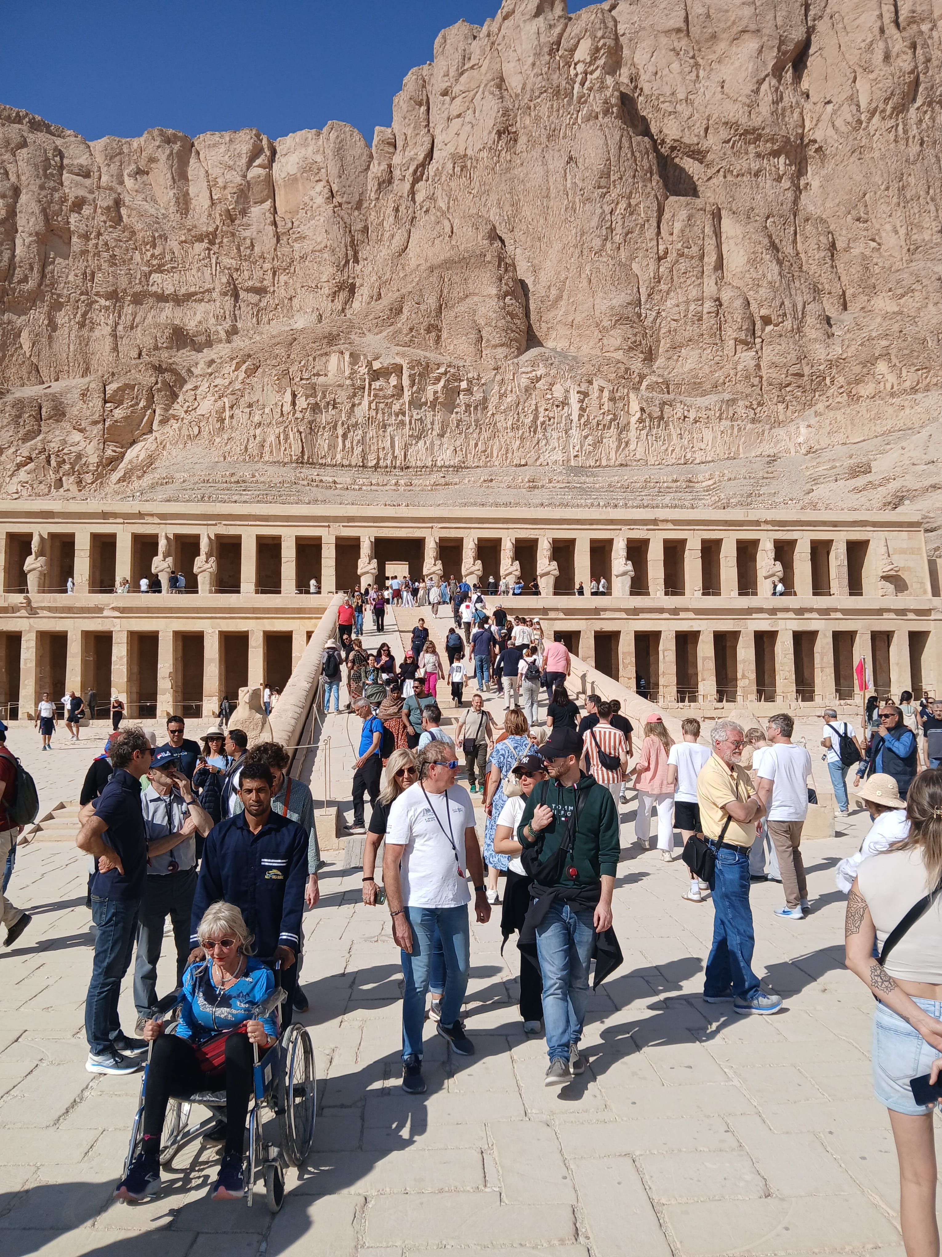 Crowd of tourists on the central incline pathway leading to Hatshepsut temple in Luxor 