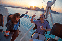 A couple toasting with champagne while floating in the sky at Flying Cup Dubai.