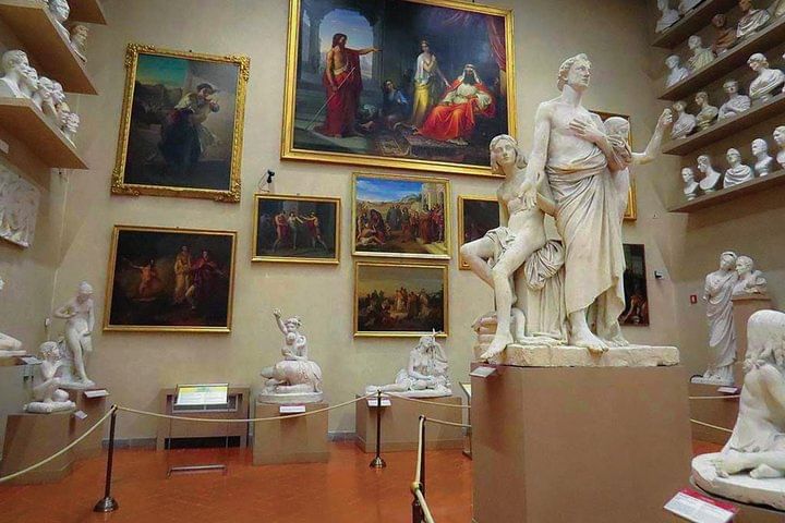 View of a secondary hall of the Accademia Gallery with sculptures and paintings