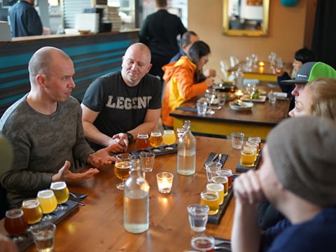 A group of guests sampling different beers while chatting