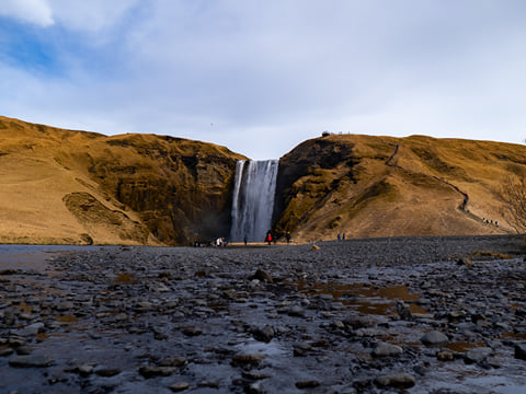 Our tallest waterfall on this journey, Skogafoss, we enjoy its frequent rainbows or climb the stairs to the top.