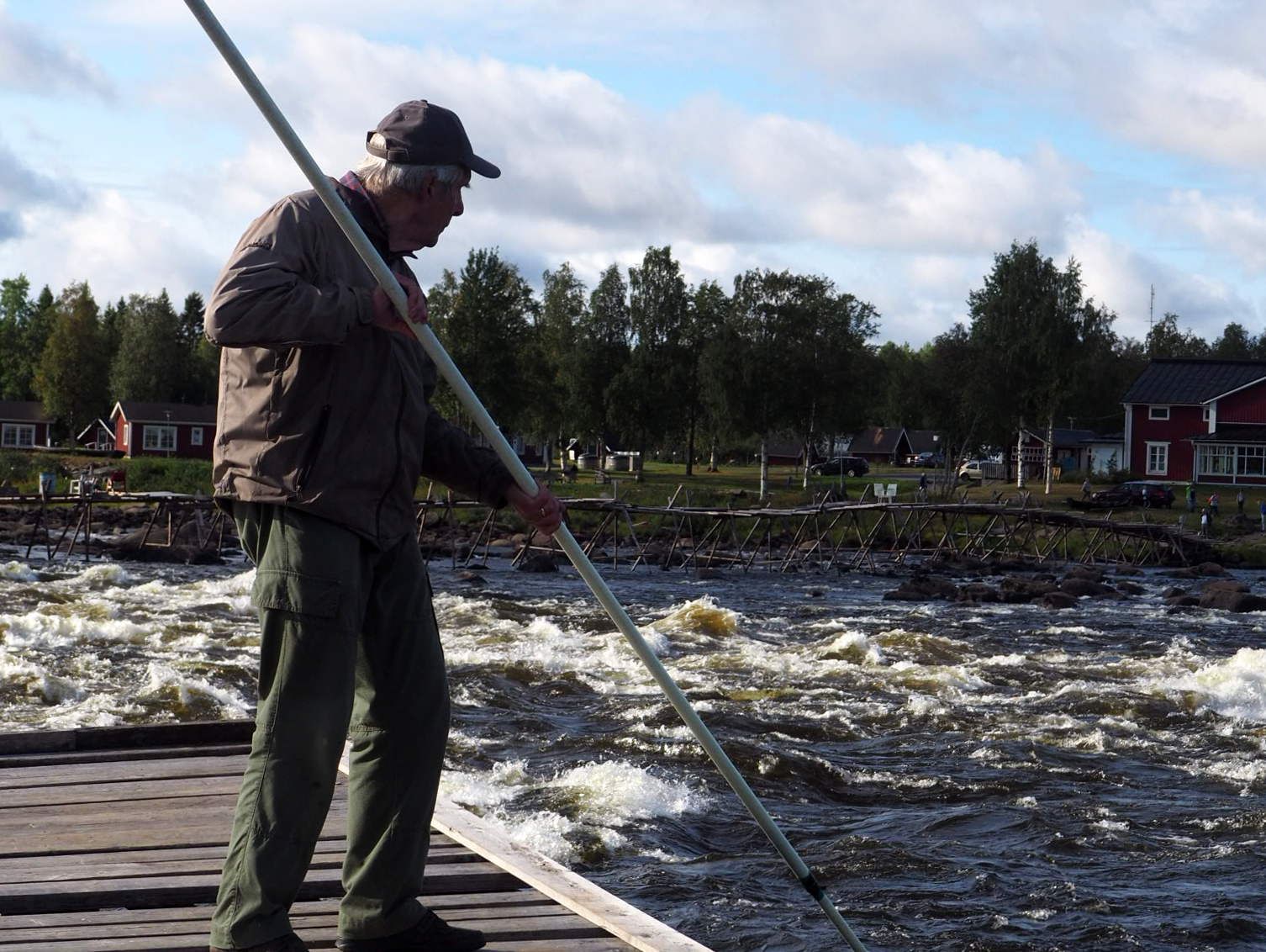 An old man fishing from a pier.
