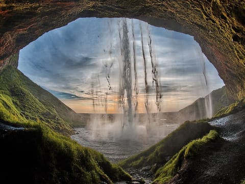Walk behind Seljalandsfoss waterfall and feel the power of the elements