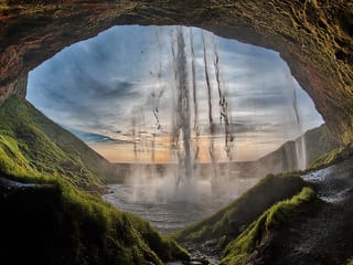 Walk behind Seljalandsfoss waterfall and feel the power of the elements