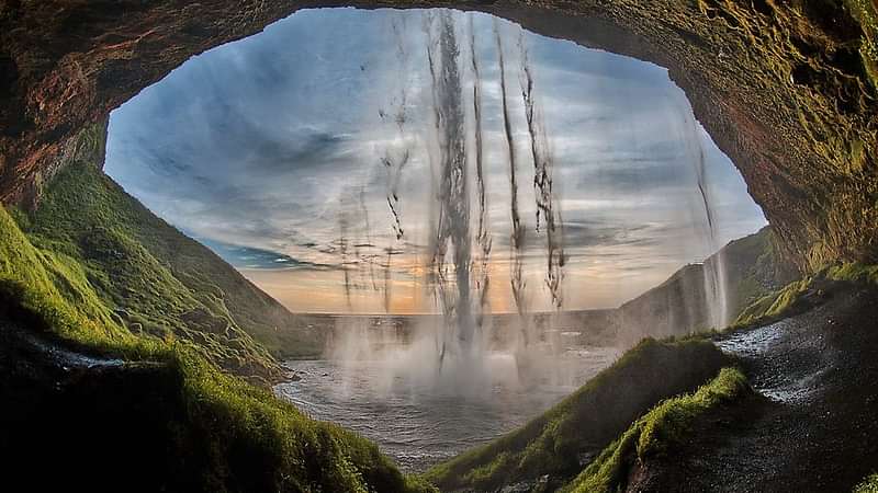 Walk behind Seljalandsfoss waterfall and feel the power of the elements