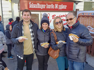 A family enjoying the Icelandic hot dog at the original food stall which dates from 1937