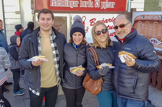 A family enjoying the Icelandic hot dog at the original food stall which dates from 1937