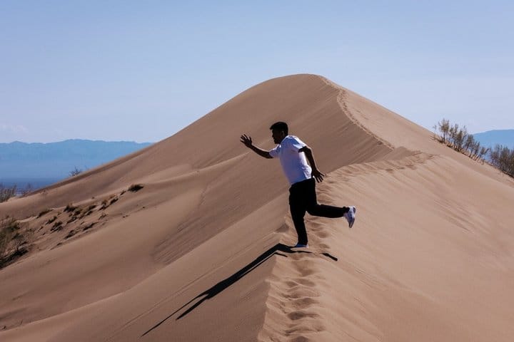 Singing Dune landscape with sandy hills and dry desert terrain.