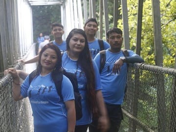 Hikers posing on a suspension bridge.