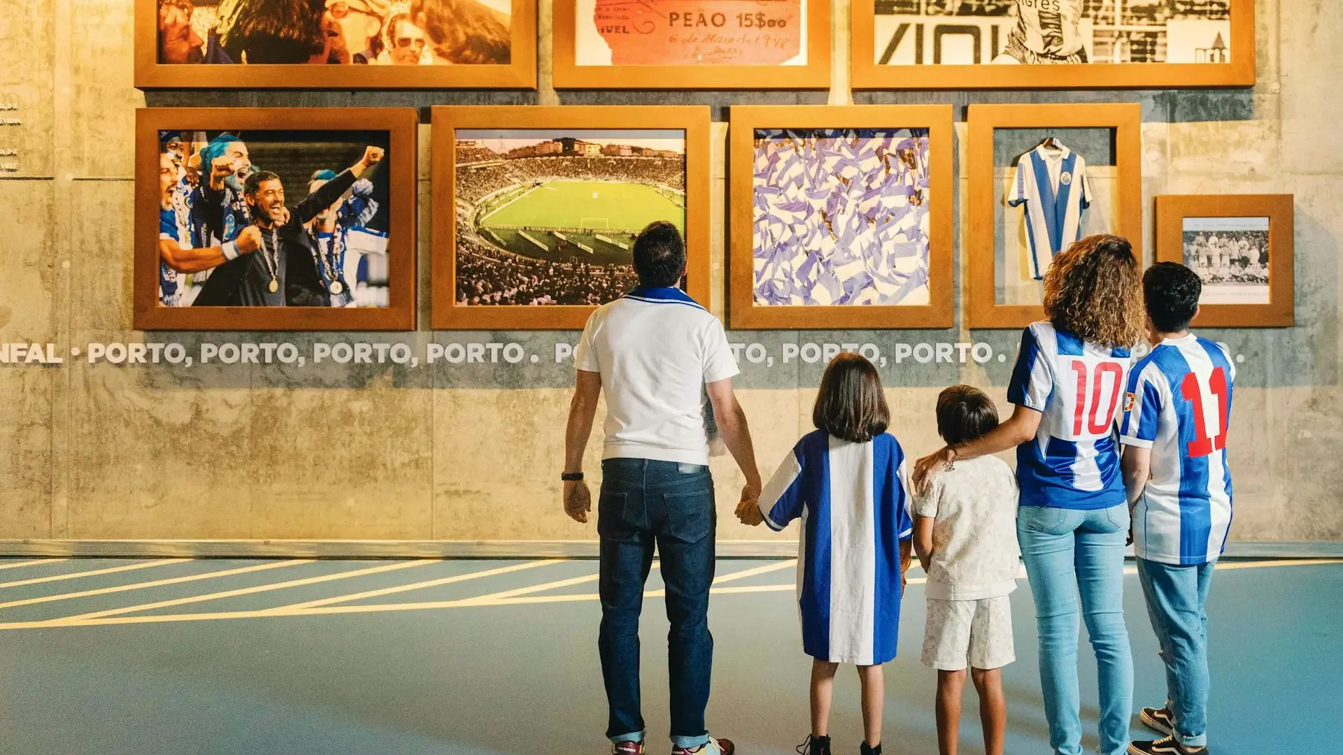 A family of five views framed photographs and memorabilia on a museum wall at FC Porto Museum & Dragão Stadium ticket.
