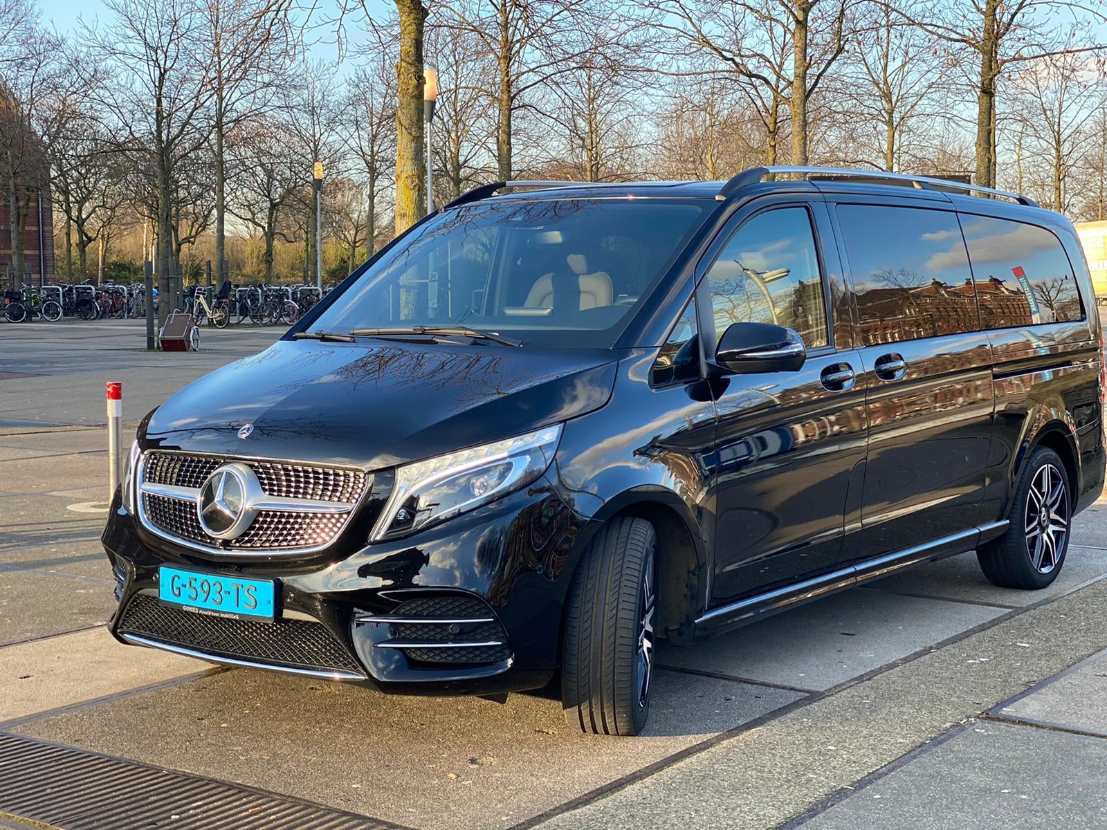 A black Mercedes-Benz V-Class luxury minivan parked outdoors, featuring tinted windows, spacious passenger seating and a sleek exterior.