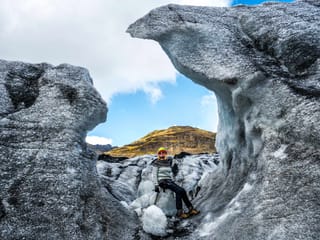 Woman sitting around icicle skulptures.