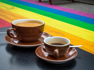 Two cups of coffee on a table next to the Rainbow Street