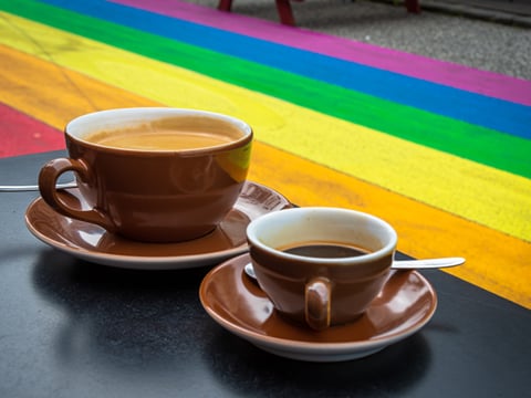 Two cups of coffee on a table next to the Rainbow Street
