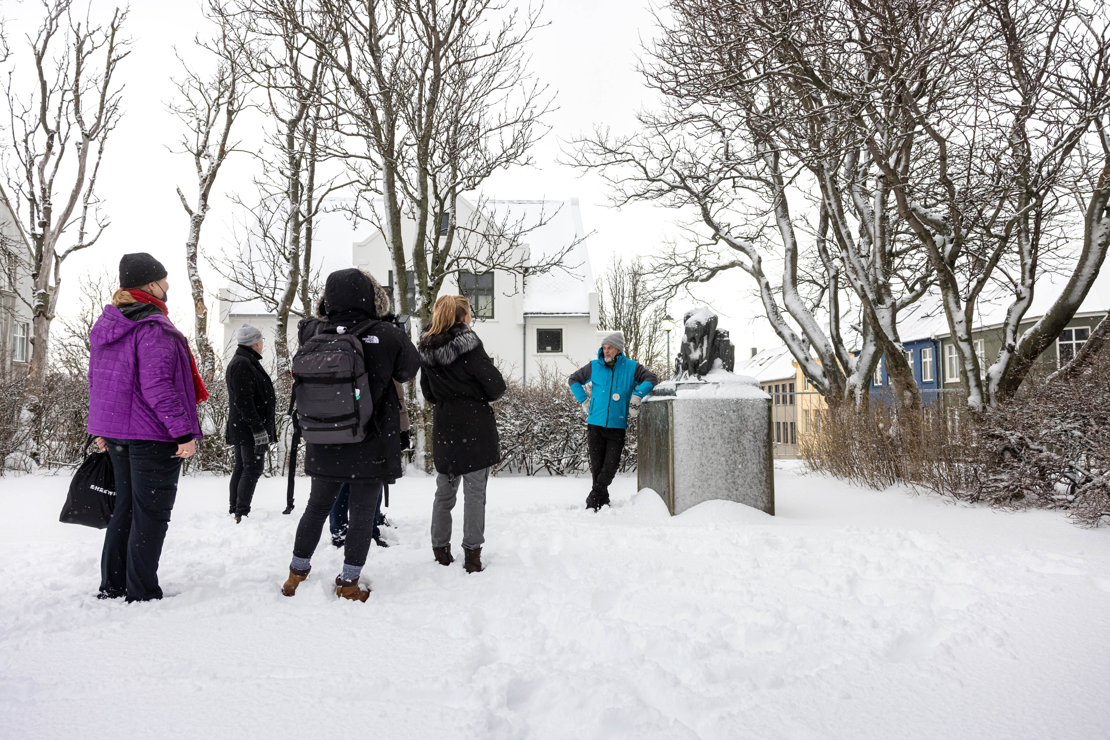 A guide from Your Friend in Reykjavik in front of a monument sharing a story.