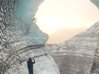 Man taking a photo inside an ice cave.