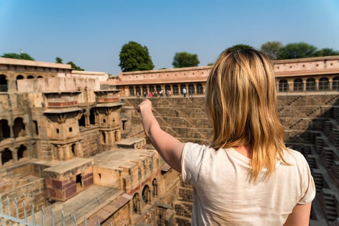 Girl Traveler Pointing To Famous Stepwell Chand Baori